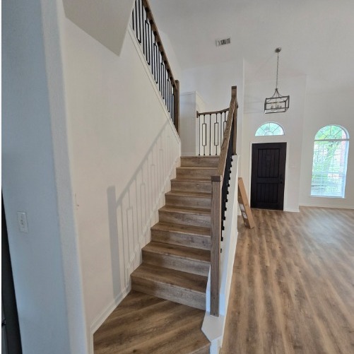 Wood-look plank flooring through an entry and staircase