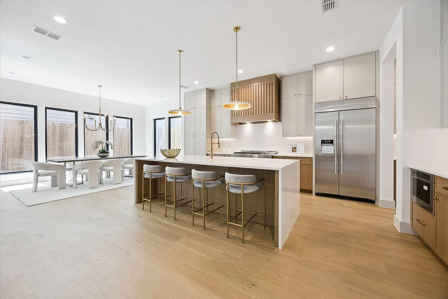 Novara kitchen with a large working island, light cabinetry and warm wood details